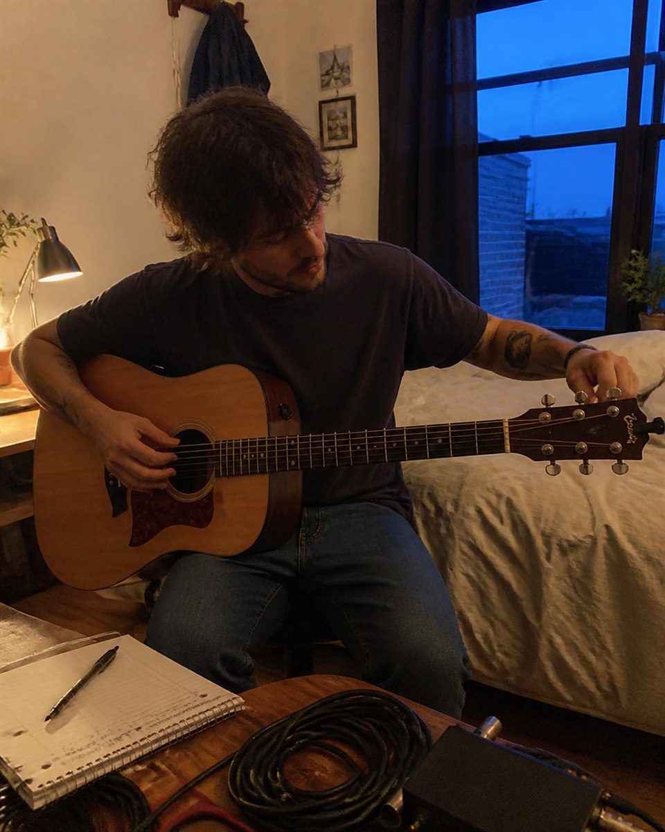 Music creator tuning a guitar during rehearsal